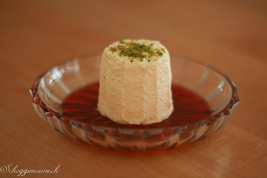 Weisse Schokoladenmousse mit Pistazien auf Cornelkirschensaft